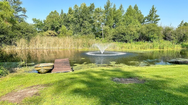 view of community featuring a lawn and a water view