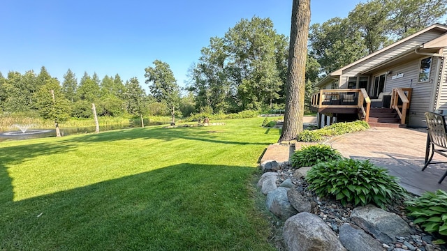 view of yard featuring a deck and a patio