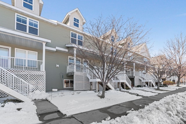 snow covered property with stairs