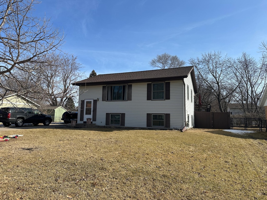 view of front of home with a front lawn and fence