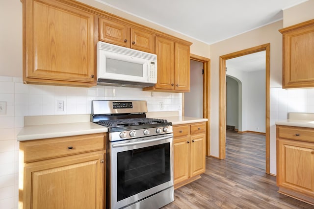 kitchen featuring light countertops, stainless steel gas stove, and white microwave