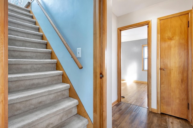 stairs featuring wood finished floors and baseboards