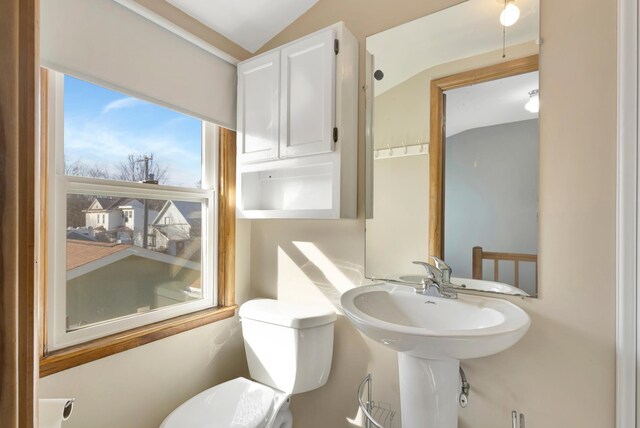 half bathroom with vaulted ceiling and toilet