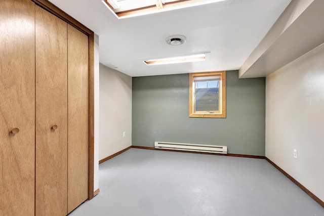 unfurnished bedroom with baseboards, concrete floors, a baseboard heating unit, and a closet