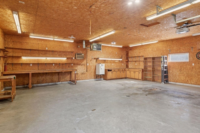 garage with a workshop area, an AC wall unit, and a garage door opener