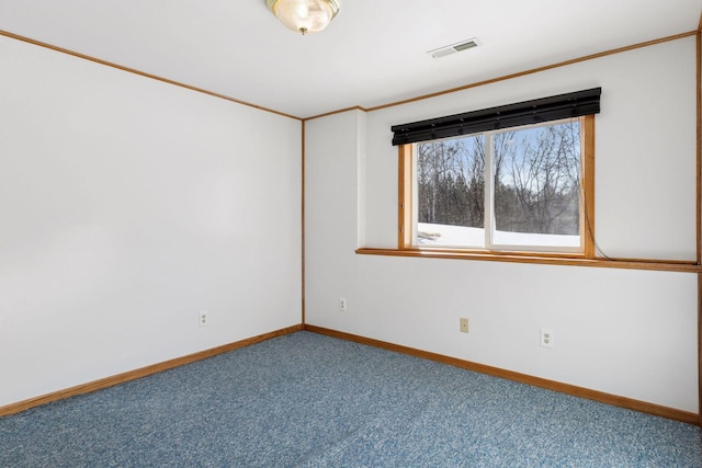 spare room featuring baseboards, visible vents, carpet floors, and ornamental molding