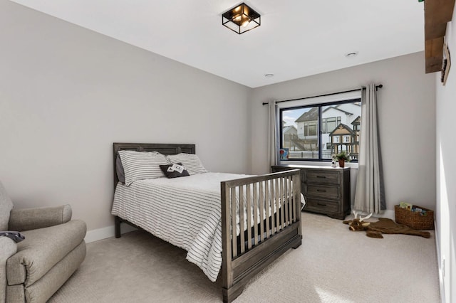 bedroom with light carpet and baseboards