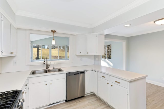 kitchen with a sink, a peninsula, white cabinets, and stainless steel appliances