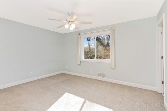 carpeted empty room with a ceiling fan, baseboards, and visible vents