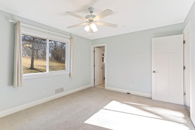 unfurnished bedroom featuring visible vents, a ceiling fan, baseboards, and light carpet