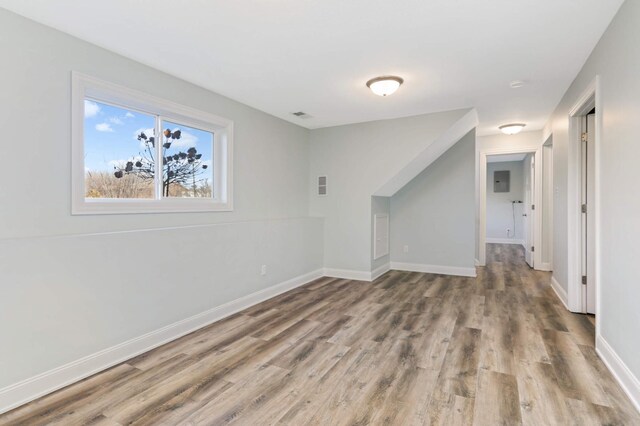 interior space with baseboards, wood finished floors, and visible vents