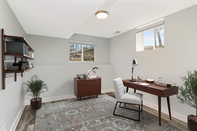 home office with baseboards, plenty of natural light, wood finished floors, and visible vents
