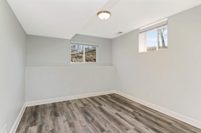 interior space with baseboards, visible vents, a healthy amount of sunlight, and wood finished floors
