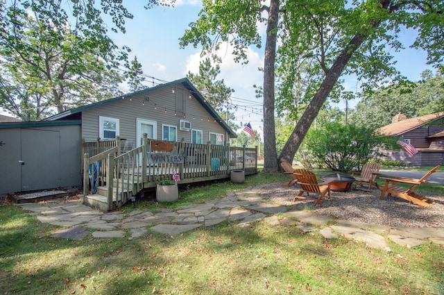 back of house featuring a deck and a fire pit