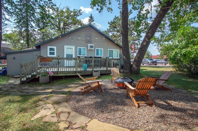 back of house featuring a fire pit and a deck