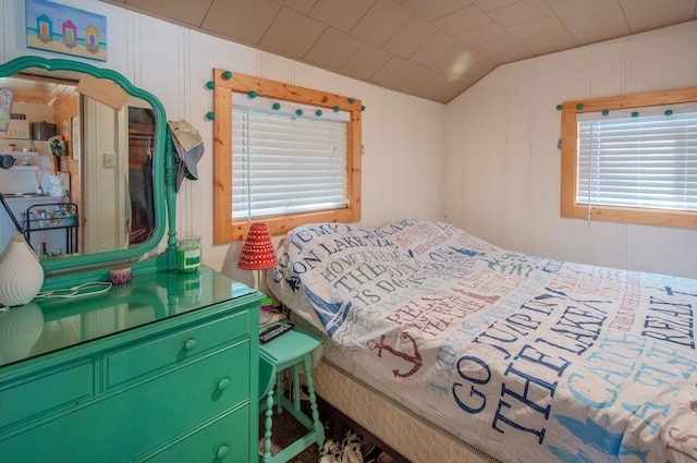 bedroom with lofted ceiling and a decorative wall