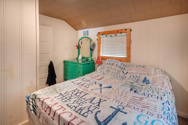 bedroom featuring a decorative wall and lofted ceiling