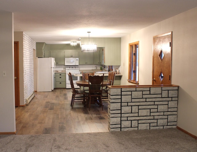 dining space featuring baseboards, wood finished floors, baseboard heating, a textured ceiling, and carpet flooring