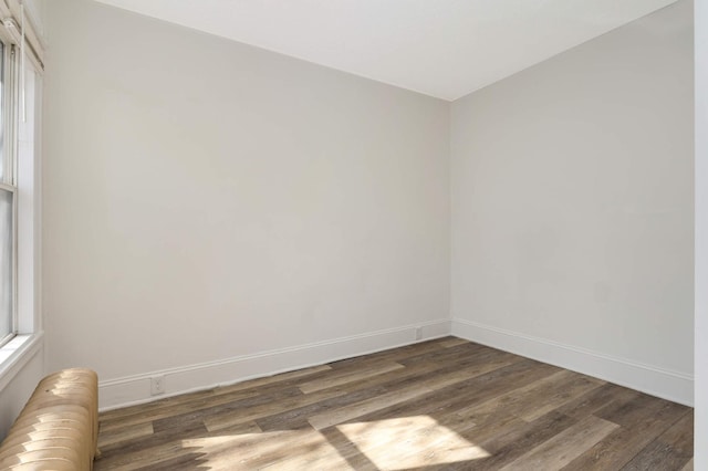 unfurnished room featuring baseboards and wood finished floors