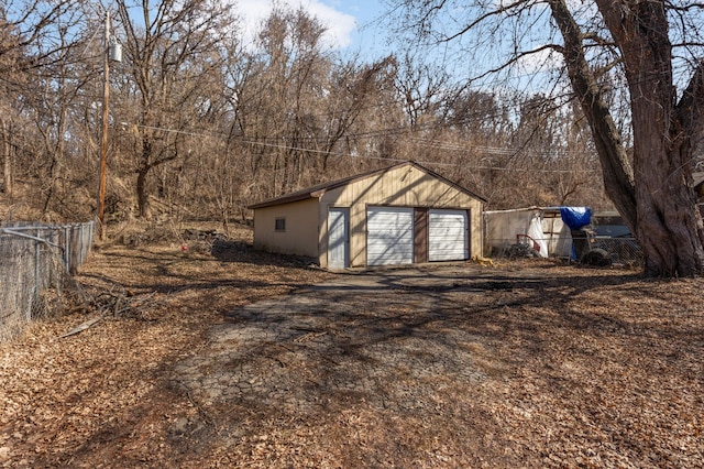 detached garage featuring fence