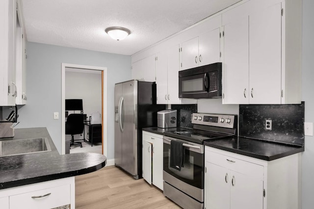 6719 Ewing Ave N, Brooklyn Center, MN 55429 - kitchen featuring stainless steel appliances, dark countertops, light wood finished floors, white cabinets, and a textured ceiling