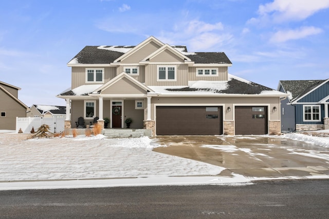 craftsman-style house with board and batten siding, fence, a porch, concrete driveway, and stone siding