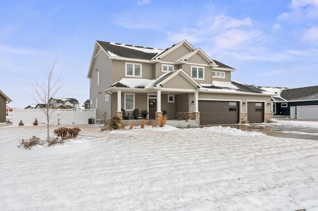 view of front of house featuring board and batten siding, fence, a porch, a garage, and stone siding