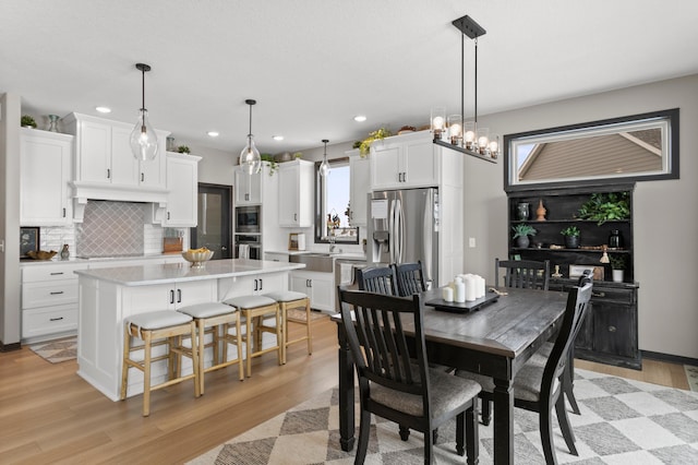 dining space with light wood-style flooring and recessed lighting