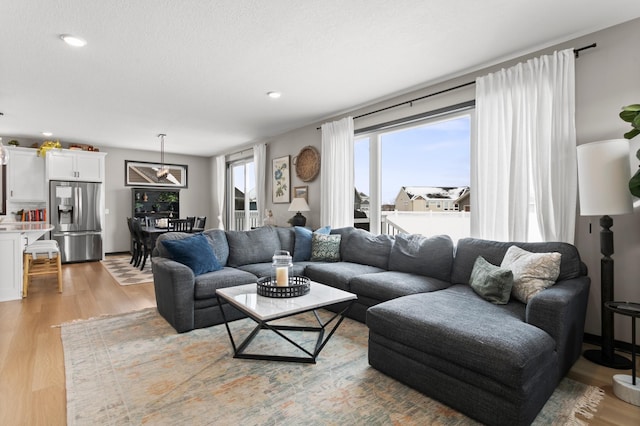 living room featuring recessed lighting, a textured ceiling, and light wood-type flooring