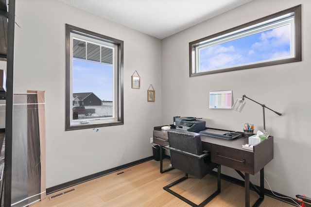 office area featuring light wood-style floors, visible vents, and baseboards