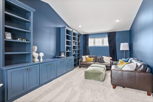 living area featuring vaulted ceiling, built in shelves, and carpet floors