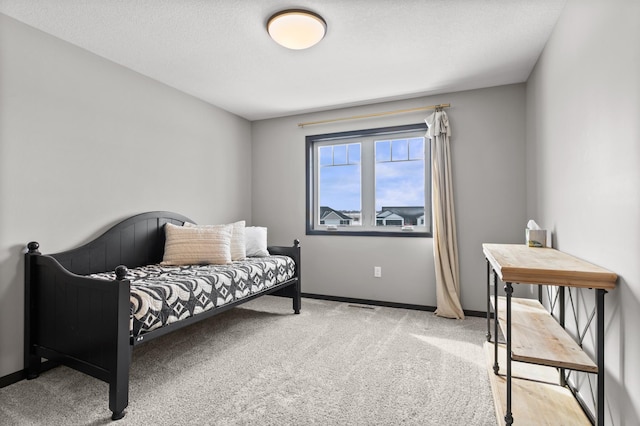 carpeted bedroom with baseboards and a textured ceiling