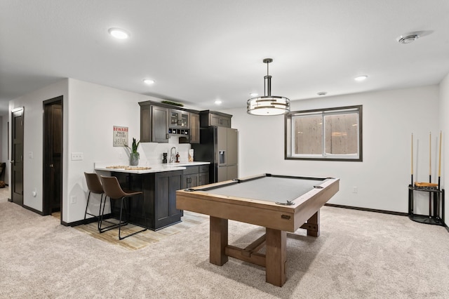 playroom featuring baseboards, light carpet, recessed lighting, wet bar, and a sink