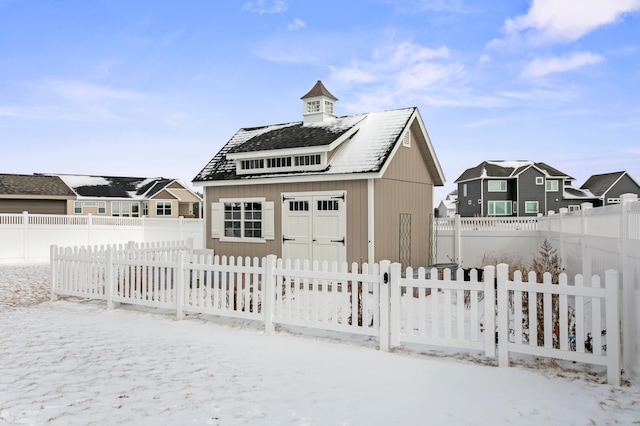 snow covered garage with fence