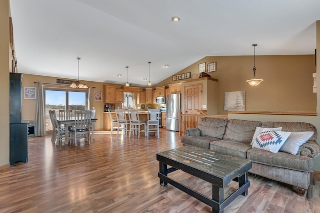 living area with lofted ceiling and wood finished floors