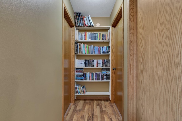 hallway featuring a textured ceiling and wood finished floors