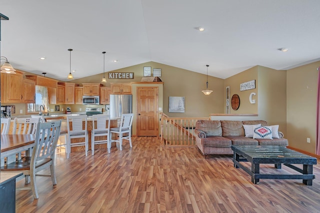 living area featuring lofted ceiling, light wood-type flooring, and recessed lighting