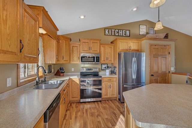 kitchen with light wood finished floors, lofted ceiling, stainless steel appliances, light countertops, and a sink