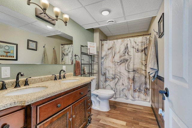 full bath featuring a paneled ceiling, a sink, toilet, and wood finished floors