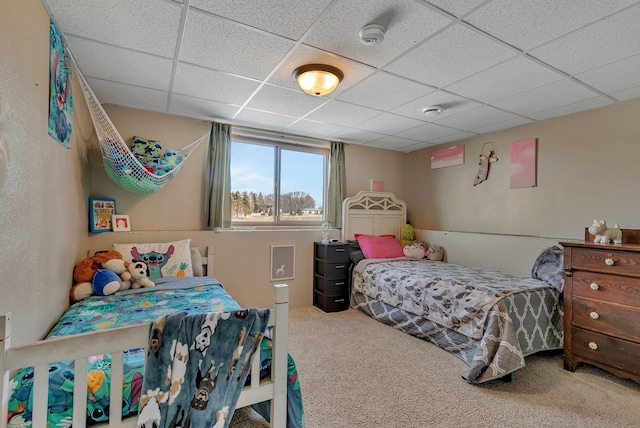 bedroom with a drop ceiling and carpet flooring