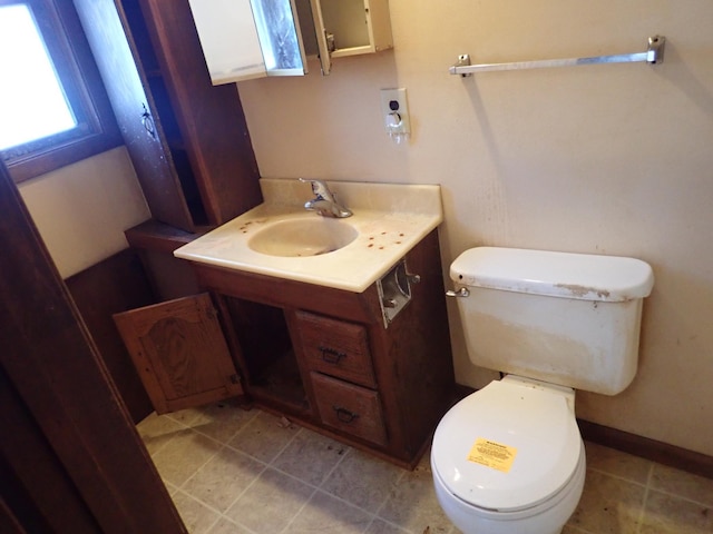 bathroom featuring toilet, tile patterned flooring, baseboards, and vanity