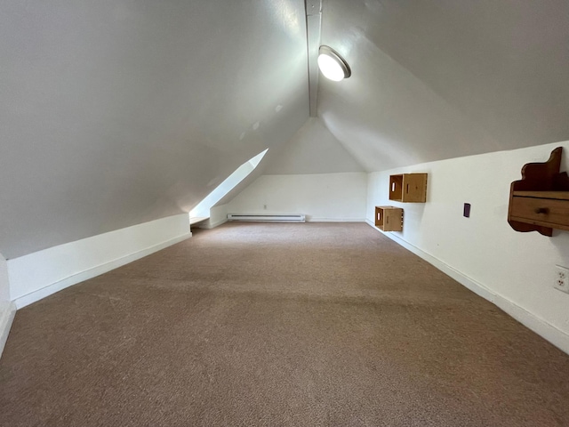 additional living space with a baseboard heating unit, vaulted ceiling, carpet, and baseboards