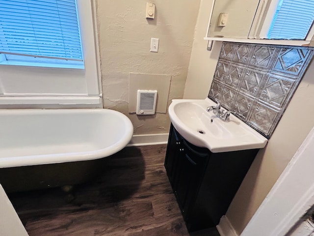 253 Richmond St, Saint Paul, MN 55102 - bathroom featuring vanity, a soaking tub, and wood finished floors