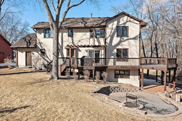 back of house featuring a patio, a pergola, a carport, a fire pit, and a deck