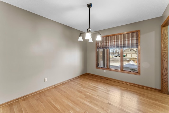 unfurnished room featuring light wood-style flooring and baseboards