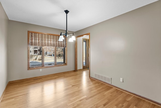 unfurnished dining area featuring light wood-style flooring and visible vents