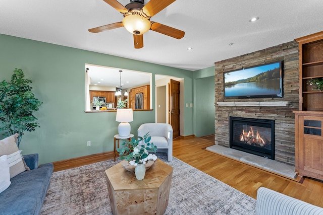 living room featuring a fireplace, recessed lighting, wood finished floors, and baseboards