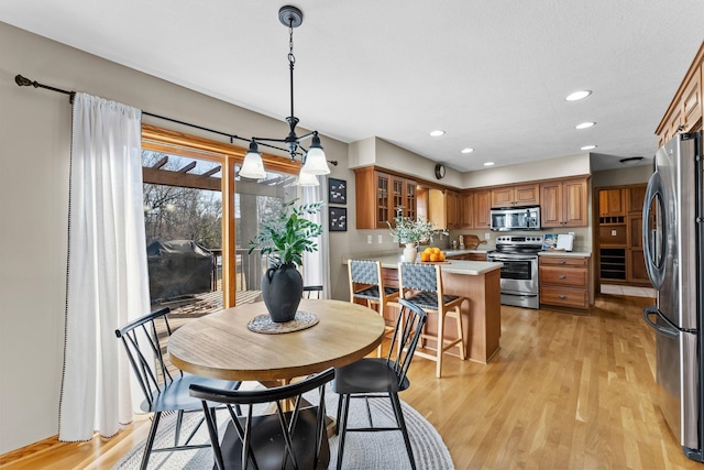 dining space with recessed lighting and light wood-type flooring