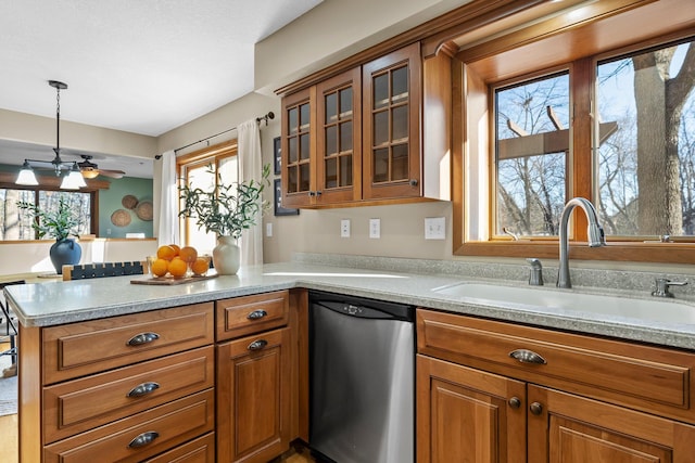 kitchen featuring a peninsula, a sink, glass insert cabinets, dishwasher, and brown cabinets