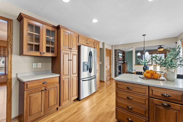 kitchen featuring brown cabinetry, stainless steel refrigerator with ice dispenser, and light countertops